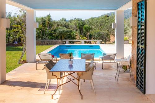 a patio with a table and chairs next to a swimming pool at Sa Plana in Son Servera