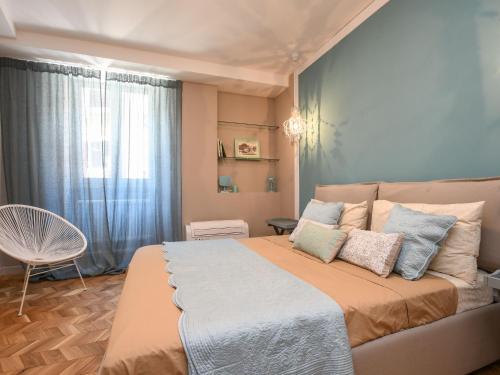 a bedroom with a bed and a chair and a window at Luxury modern apartment by the lake in Salò