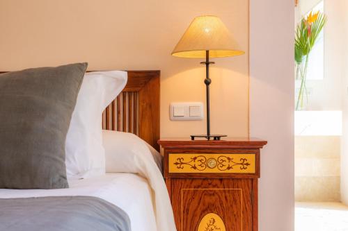 a bedroom with a bed with a lamp on a night stand at Sa Plana in Son Servera