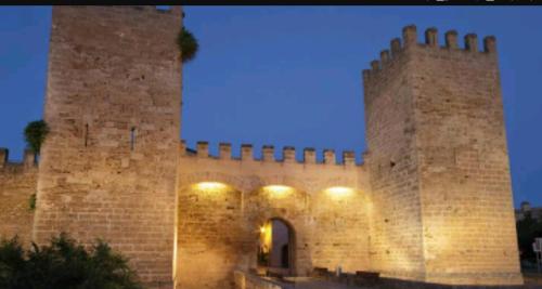 an old brick building with a gate at night at Casa Convent in Alcudia