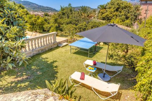 a patio with an umbrella and two chairs and a table at Sa Teulera Soller in Sóller
