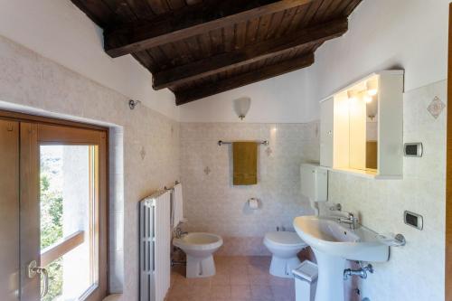 łazienka z 2 toaletami, umywalką i lustrem w obiekcie Casa Rita app 2 w Tremosine Sul Garda