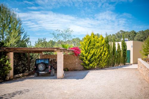 a parking lot with a jeep parked under a wooden arch at Sa Lluna in Sant Josep