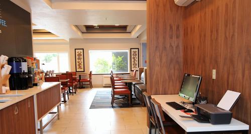 a restaurant with tables and chairs and a computer on a counter at Holiday Inn Express Hotel & Suites Ashland by IHG in Ashland