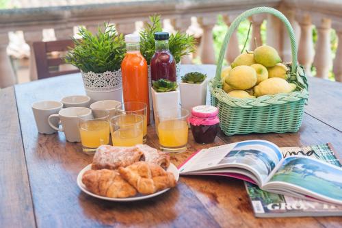 a table with a basket of bread and juice and a book at Can Guixa in Sóller