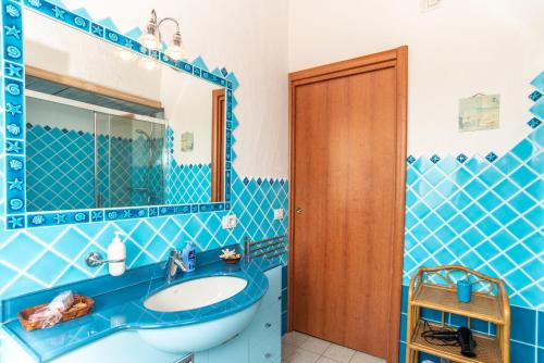 bagno blu con lavandino e specchio di Splendida Vista su Tavolara a Porto San Paolo
