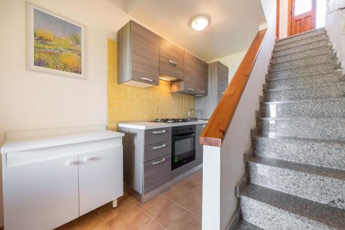 a kitchen with stairs leading up to a kitchen with a stove at Accu is prezzus I 30mt dal mare in Villasimius