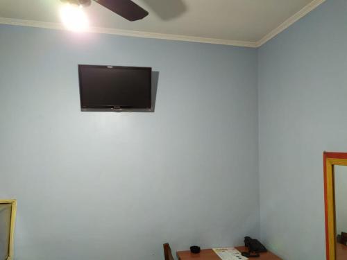 einen Flachbild-TV, der an einer weißen Wand hängt in der Unterkunft Hotel Dueto in São Bernardo do Campo