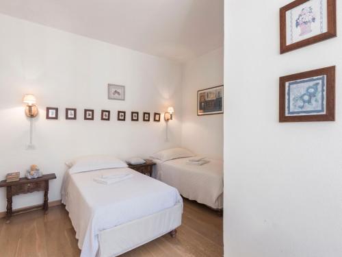 two beds in a room with white walls at Wonderful Villa Botticelli in Cavaion Veronese