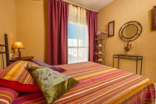 コニル・デ・ラ・フロンテーラにあるApartamento Luzのベッドルーム1室(大型ベッド1台、窓付)
