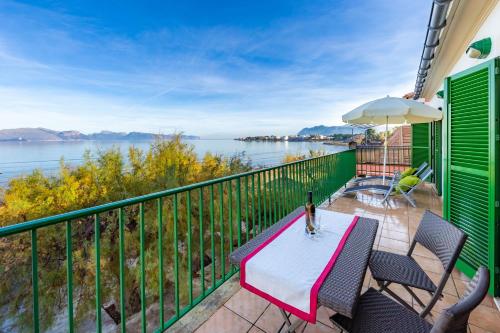 una mesa y sillas en un balcón con vistas al agua en Marina, en Alcudia