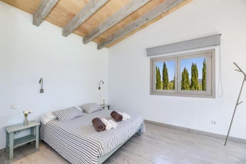 a white room with a couch and a window at Na Maians in Capdepera