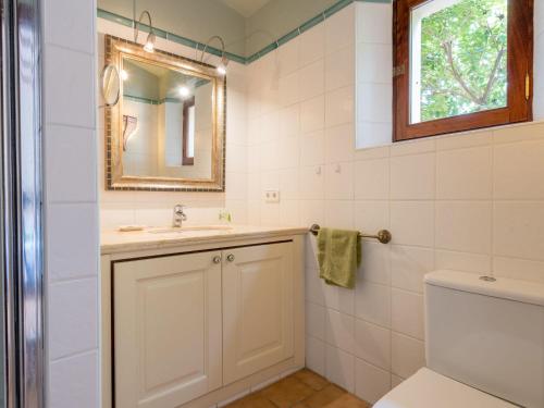 a bathroom with a sink and a mirror and a toilet at Ses Mires in Cala Santanyi