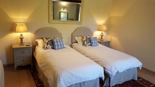 - 2 lits dans une chambre avec 2 lampes et un miroir dans l'établissement Maisonnette au coeur d'un vignoble, à Villeneuve-de-Duras