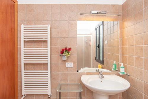 ein Bad mit einem Waschbecken und einem Spiegel in der Unterkunft Casa Fiorella in San Pantaleo