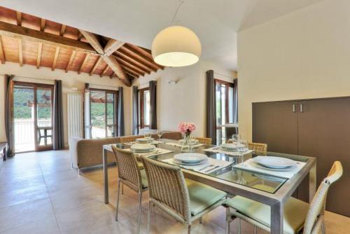 une salle à manger avec une table et des chaises en verre dans l'établissement Villetta Natura Casa A, à Rio nellʼElba