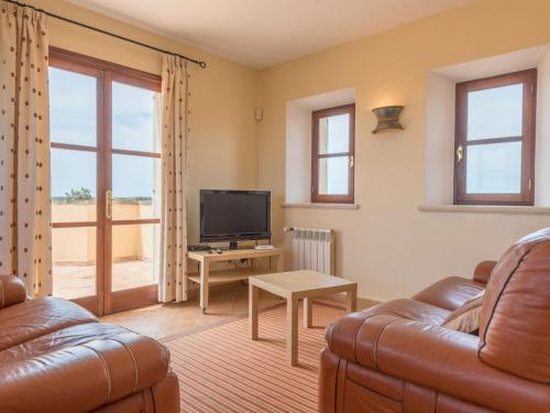 a living room with a couch and a television at Ses Mires in Cala Santanyi