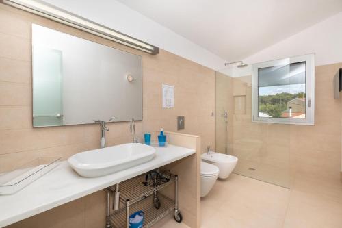 a bathroom with a sink and a toilet and a mirror at Villa Xipell 9 in Cala Santandria