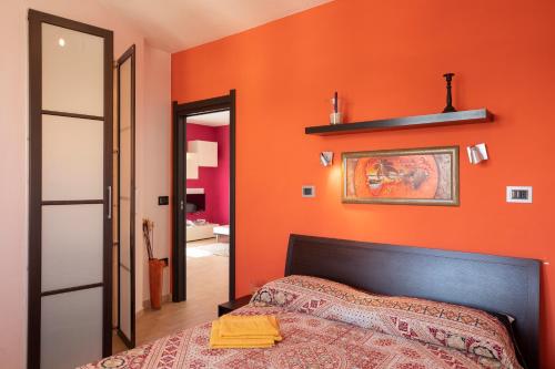 ポルト・トッレスにあるCasa Vacanze Porto Torresのオレンジ色の壁のベッドルーム(ベッド1台、鏡付)