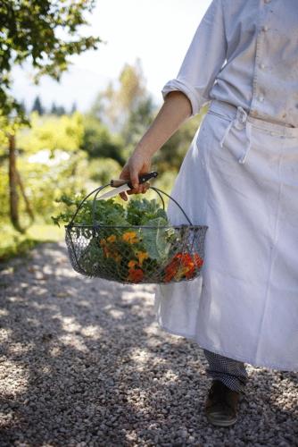 a woman holding a basket of flowers on a path at Biohotel Grafenast in Pill