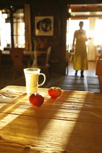 two tomatoes and a cup of coffee on a wooden table at Biohotel Grafenast in Pill