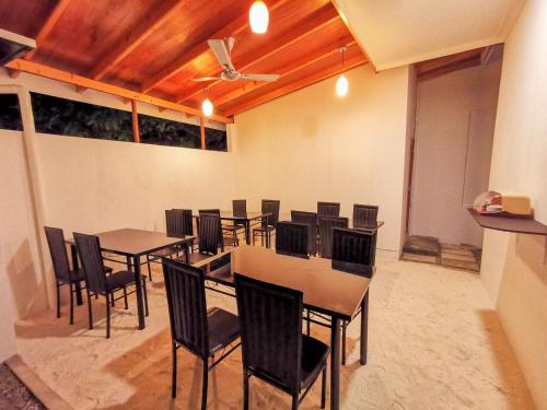 Sky Inn Thoddoo في ثودو: غرفة طعام بها طاولات وكراسي وسقف