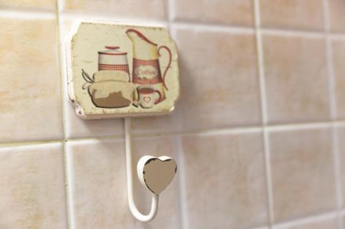 a socket on a tiled bathroom wall with a mirror at Simona Giardino in Fetovaia