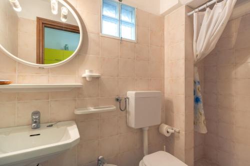 bagno con lavandino, servizi igienici e specchio di Simona Giardino a Fetovaia