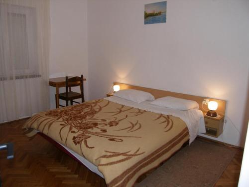 1 dormitorio con 1 cama y 1 mesa con 2 lámparas en Apartments Mirko - 100m from beach, en Ugrinići