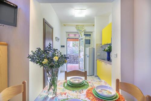 a kitchen with a table with a vase of flowers on it at Simona Giardino in Fetovaia
