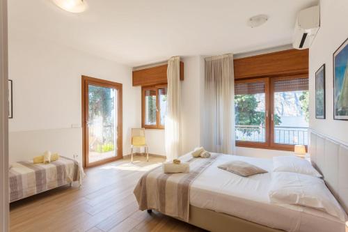 a bedroom with two beds and a large window at Appartamento Randa in Malcesine