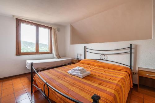 a bedroom with a bed and a window at Accu is Prezzus D fronte mare in Villasimius