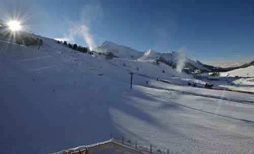 a snow covered ski slope with the sun on top at Hotel Alpenrose aktiv & sport in Kühtai