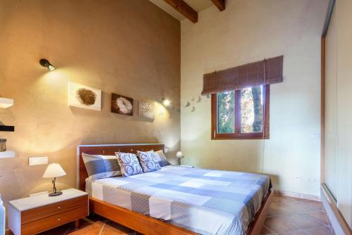 a bedroom with a bed with a blue and white comforter at Cuatro Soles in Capdepera