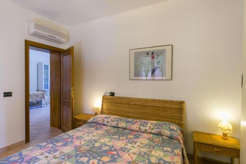 a bedroom with a bed and two lamps and a door at Appartamento Daniela Fetovaia in Campo nell'Elba