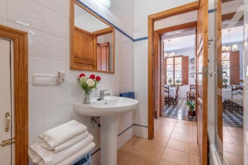 a bathroom with a sink and a vase of flowers at Can Joi in Sóller