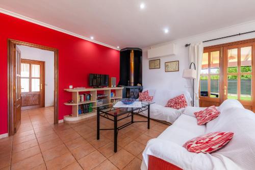 リュビにあるSon Sitgesの赤い壁と白い家具が備わるリビングルーム