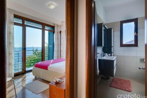 een slaapkamer met een bed en een badkamer met een douche bij Villa Niko in Kožino