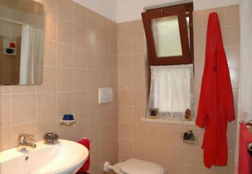 a bathroom with a sink and a toilet and a mirror at Appartamenti Le Querce - Lentisco in Capoliveri