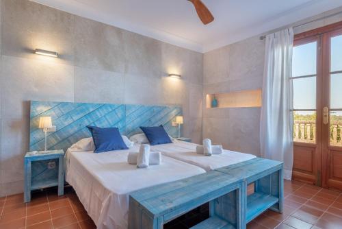 1 dormitorio con 1 cama grande y cabecero azul en Son Tomasset, en Costitx