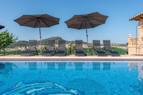 a swimming pool with umbrellas and chairs and a pool at Solluna in Son Servera