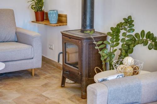 a living room with a wood stove and a couch at Sa Vinya Jove in Biniali