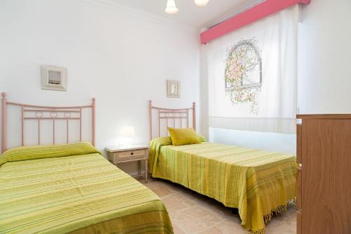 sypialnia z 2 łóżkami i oknem w obiekcie Federico 1 w mieście Conil de la Frontera