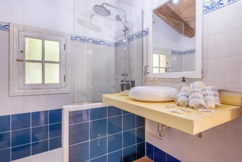 a blue and white bathroom with a sink and a mirror at Es Rafal Roig - S'aboal in Sant Llorenç des Cardassar