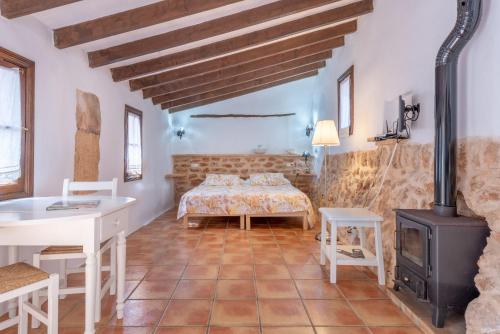 a living room with a bed and a stove at Es Rafal Roig - Es Galiner in Sant Llorenç des Cardassar