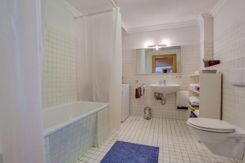 a bathroom with a tub and a toilet and a sink at Chalet am Brand in Tegernsee