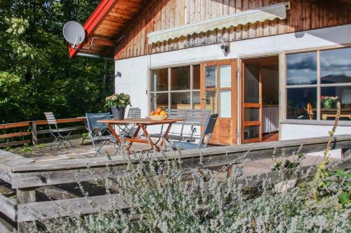 ein Holzhaus mit einem Tisch und Stühlen auf einer Terrasse in der Unterkunft Chalet am Brand in Tegernsee