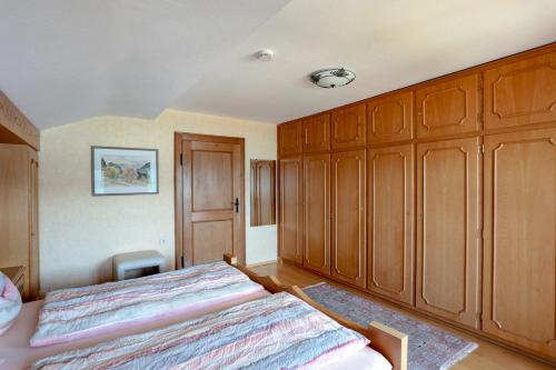 a bedroom with a bed and wooden cabinets at Ferienwohnung Landhaus Staudacher in Tegernsee