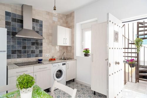 a kitchen with a washing machine and a sink at Apartamento Lola - Sólo Familias in Conil de la Frontera
