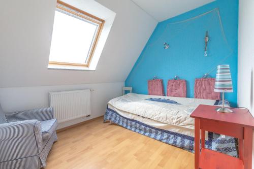 a bedroom with a bed and a blue wall at Ferienhaus Kranich in Pruchten